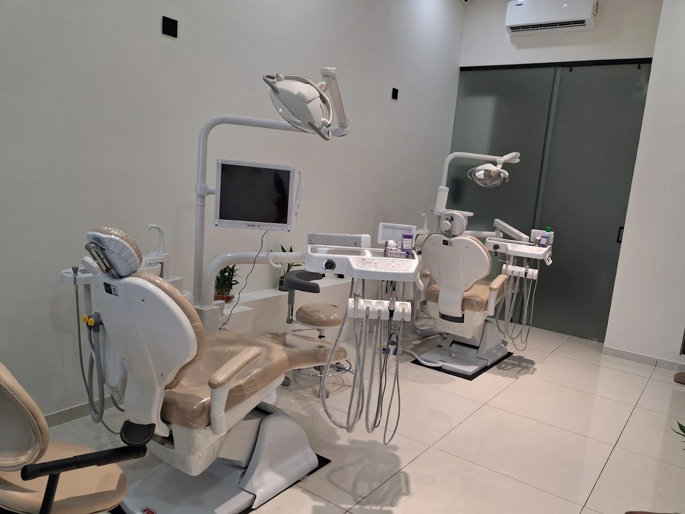 Treatment room with two dental chairs and overhead lights
