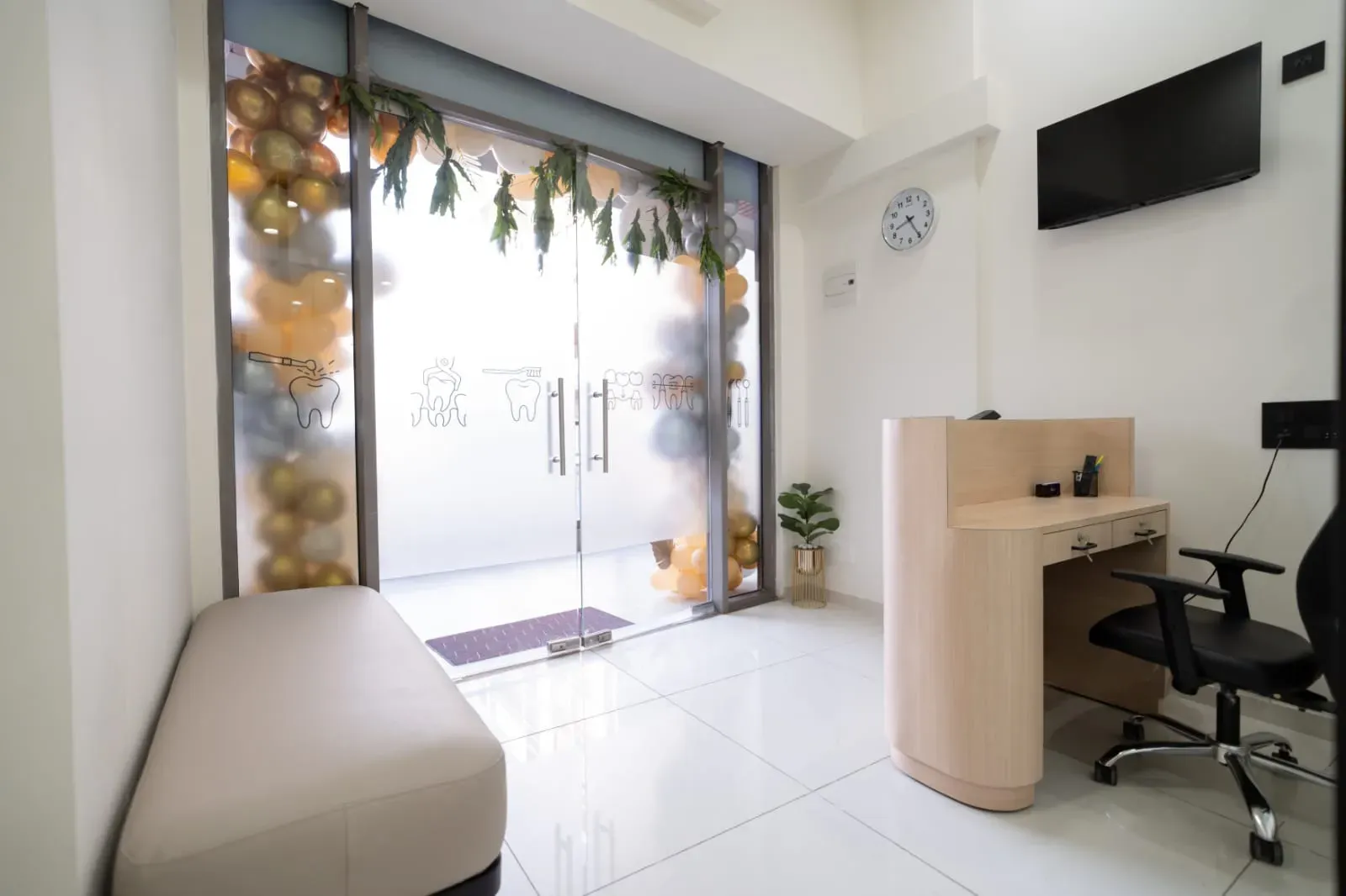 Welcoming clinic reception and air-conditioned patient waiting area with oral hygiene displays in Kudasan